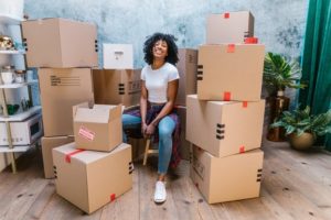 smiling black woman surrounded by cardboard boxes