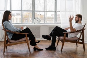 therapist and client facing each other in chairs