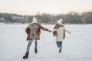 couple in winter clothes ice skating