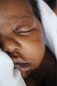 close up of sleeping newborn with brown skin