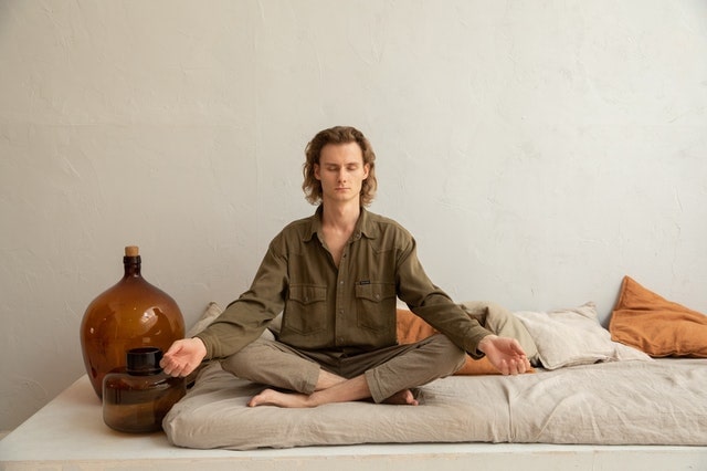 white man meditating on mat