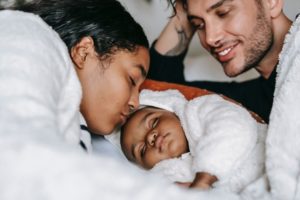 diverse parents snuggling young baby