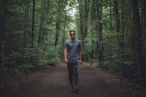 white man walking in the woods