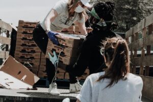 women volunteering during COVID on the back of a truck with food