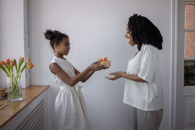black girl giving mother a gift for mother's day-therapy for postpartum anxiety